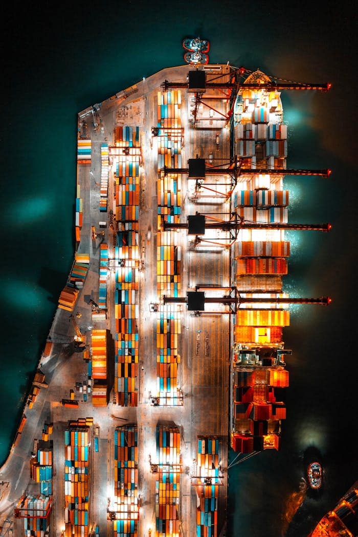 Mastering the First Impression: Your intriguing post title goes here Dramatic aerial view of a busy shipping port with colorful containers and bright lights at night.